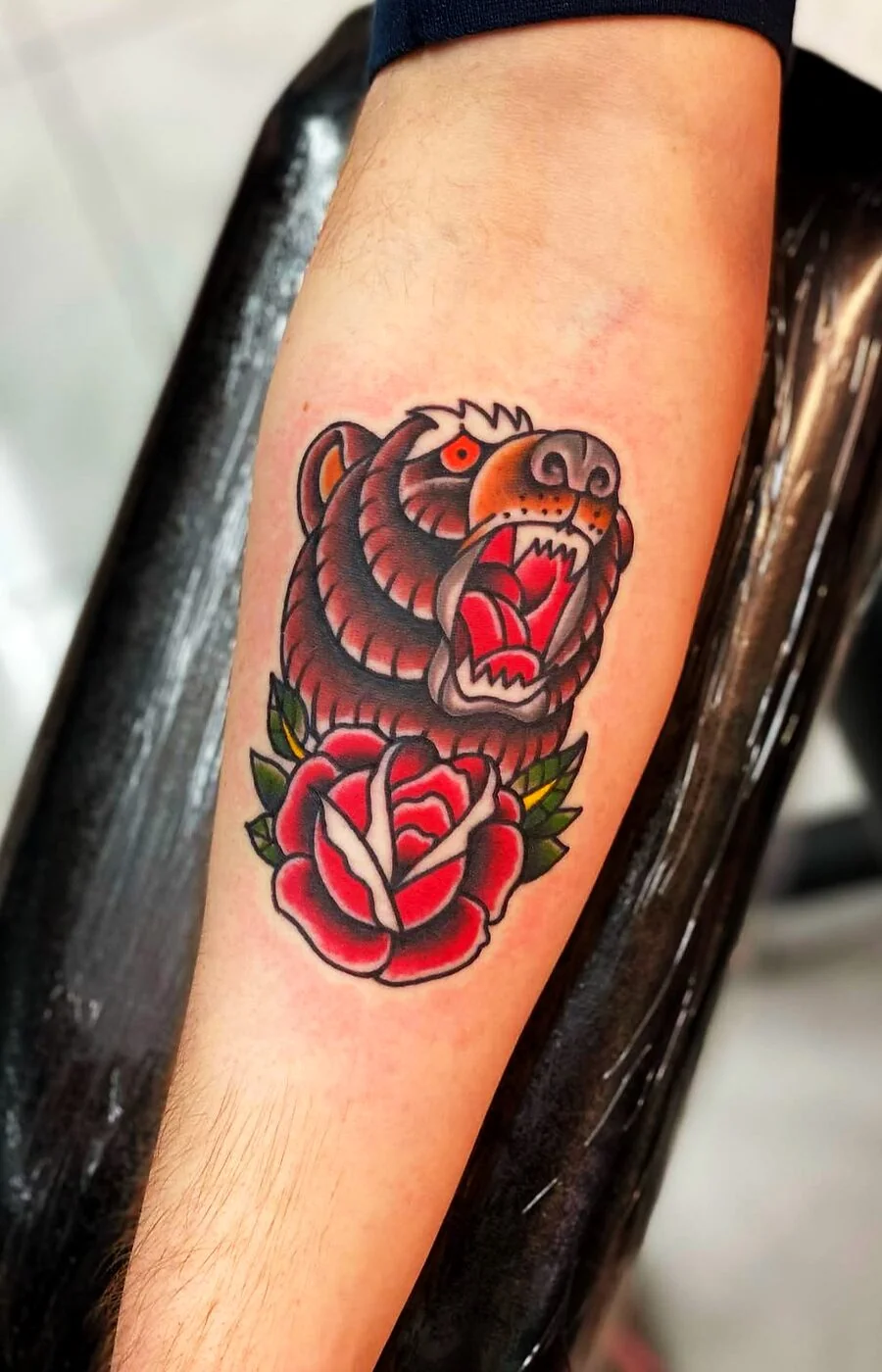 American Traditional roaring bear head with rose tattoo on forearm by 2bit (Chris Curren) at Lost at Sea Tattoo, Chinatown, Honolulu