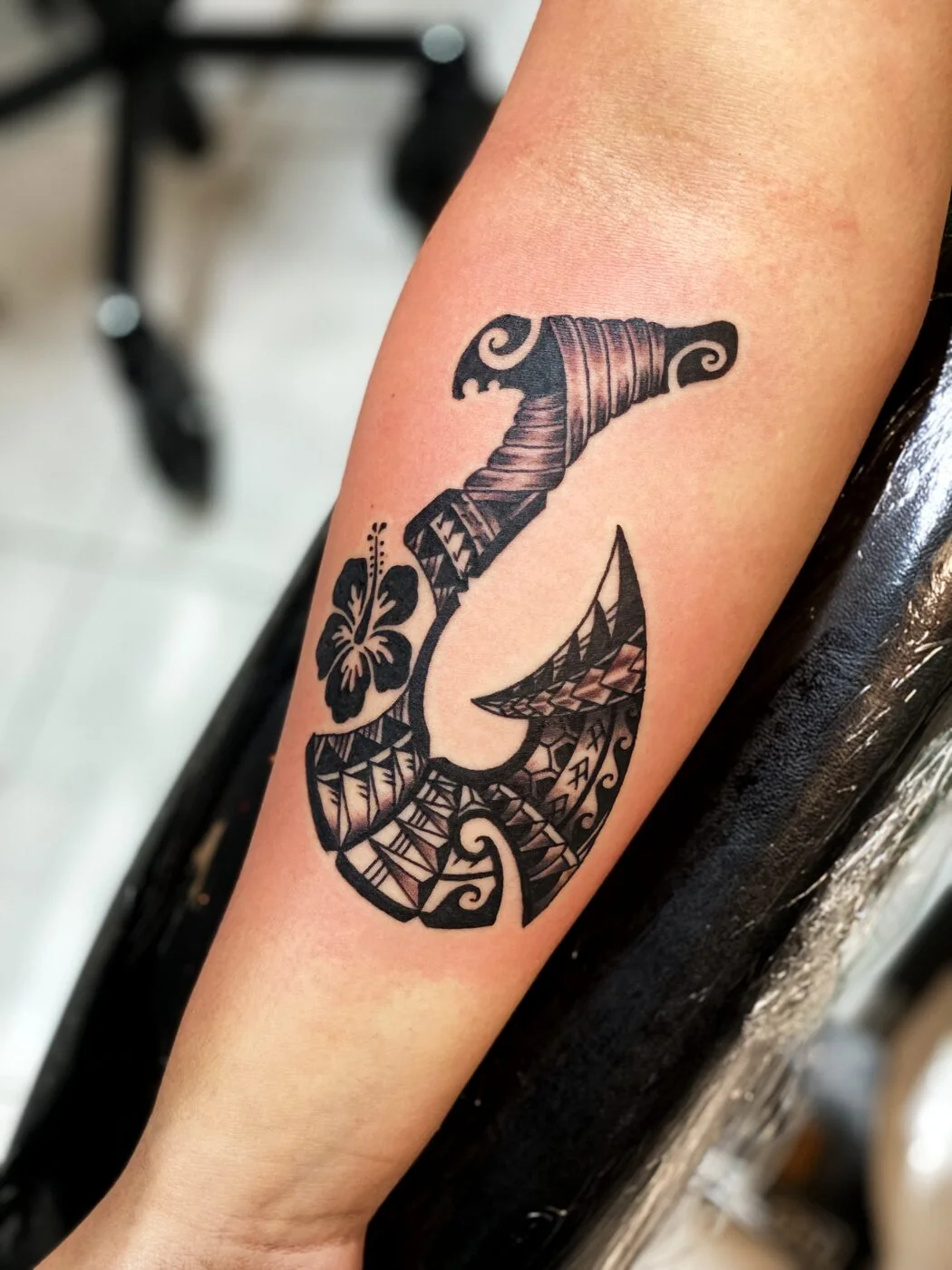 Black & Grey Polynesian fish hook (makau) with hibiscus tattoo on calf by 2bit (Chris Curren) at Lost at Sea Tattoo, Chinatown, Honolulu