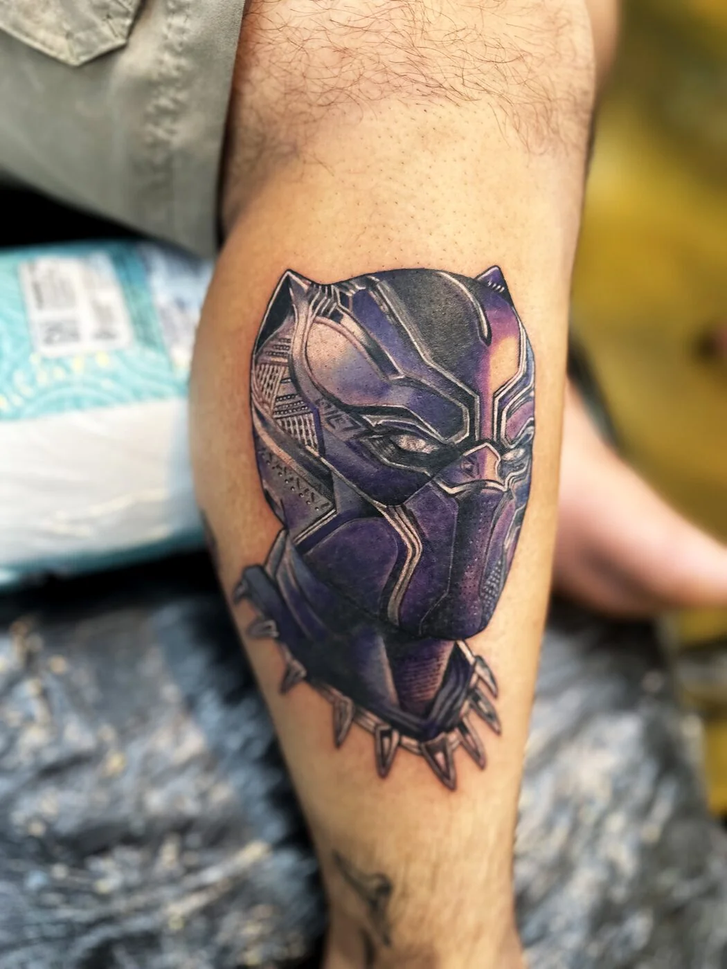 Color Realism Black Panther superhero mask with shoulder armor tattoo on calf by 2bit (Chris Curren) at Lost at Sea Tattoo, Chinatown, Honolulu