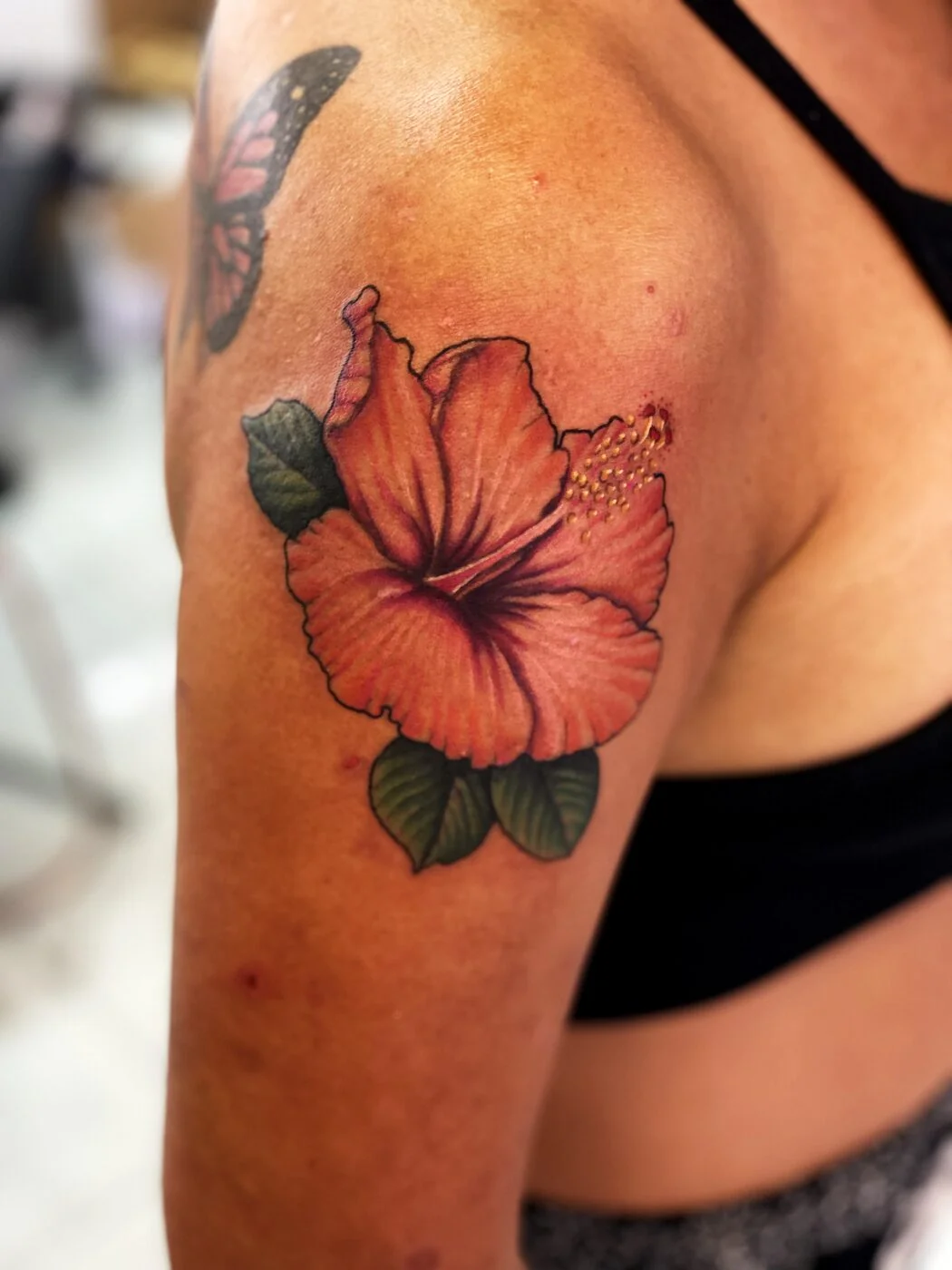 Color Realism orange hibiscus flower tattoo on shoulder by 2bit (Chris Curren) at Lost at Sea Tattoo, Chinatown, Honolulu