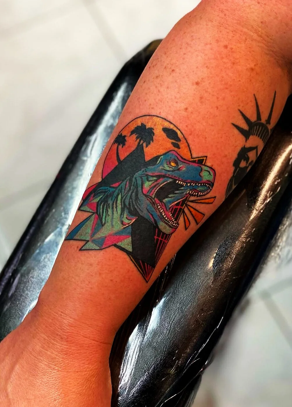 Neo-Traditional synthwave 80s velociraptor with palm trees and sunset tattoo on forearm by 2bit (Chris Curren) at Lost at Sea Tattoo, Chinatown, Honolulu